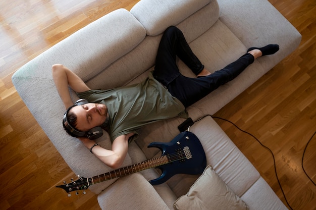 Free photo young man playing guitar at home