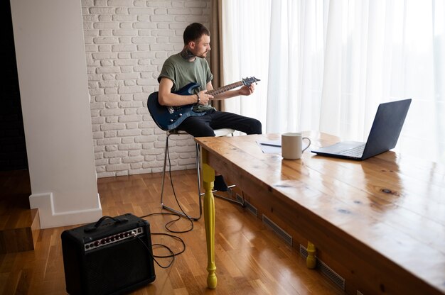 Young man playing guitar at home