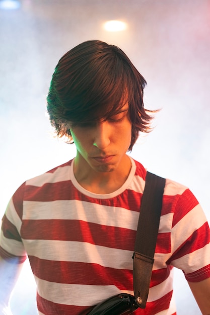 Free photo young man playing guitar music at a local event