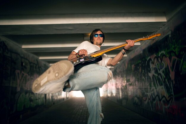 Young man playing the guitar on a street.