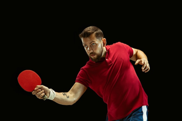 Free photo young man playing table tennis on black