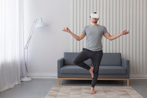 Young man playing videogames while wearing virtual reality goggles