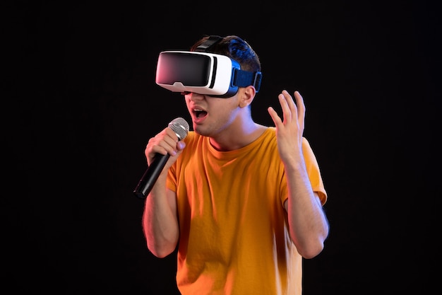 Giovane che gioca la realtà virtuale e canta sulla superficie scura