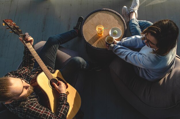 한 젊은 남자가 소녀의 평면도를 위해 기타를 연주한다