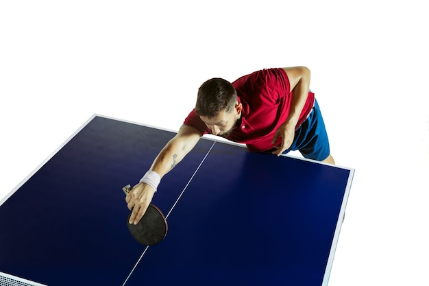 Free photo young man plays ping pong on white wall.