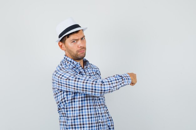 Young man pointing away in checked shirt