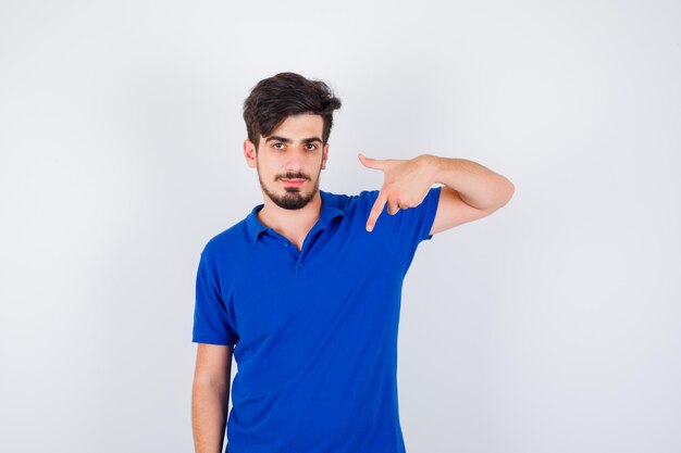 Young man pointing at himself in blue t-shirt and looking serious