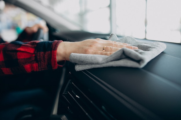 Foto gratuita giovane che lucida la sua automobile con lo straccio