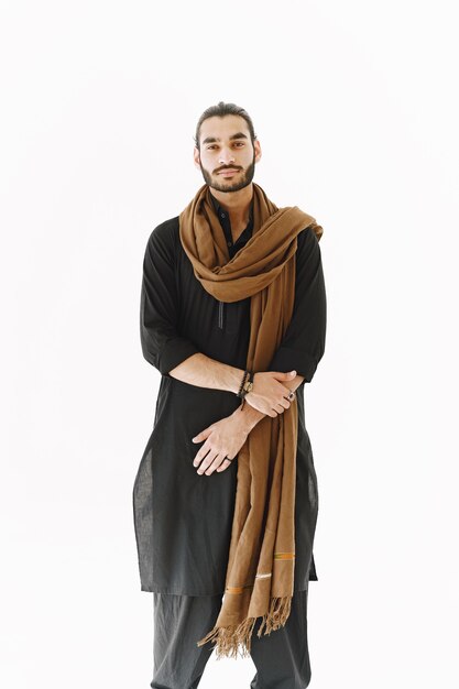 Young man posing casually over white wall.