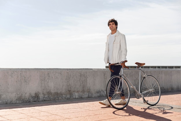 Free photo young man posing next to his bike