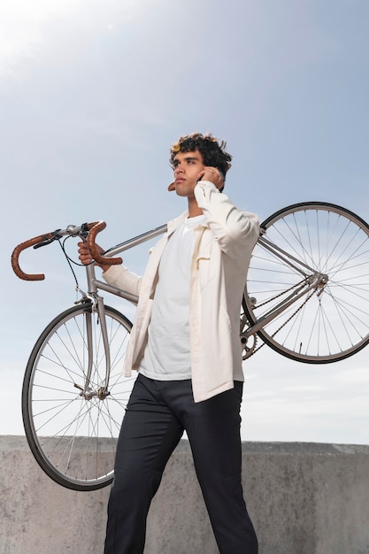 Free photo young man posing next to his bike