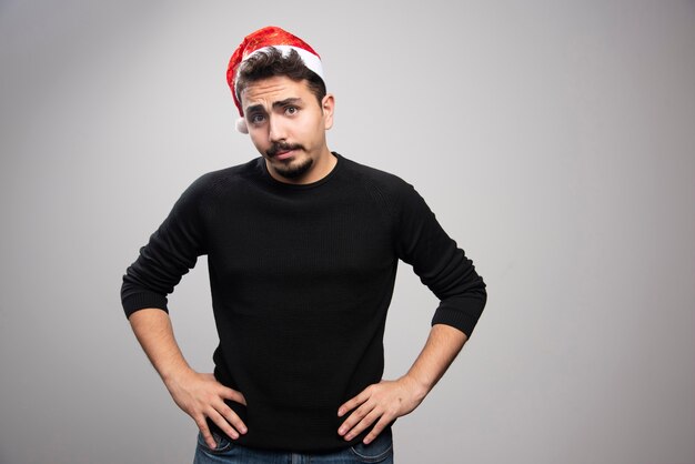 Young man posing in Santa Claus red hat. 