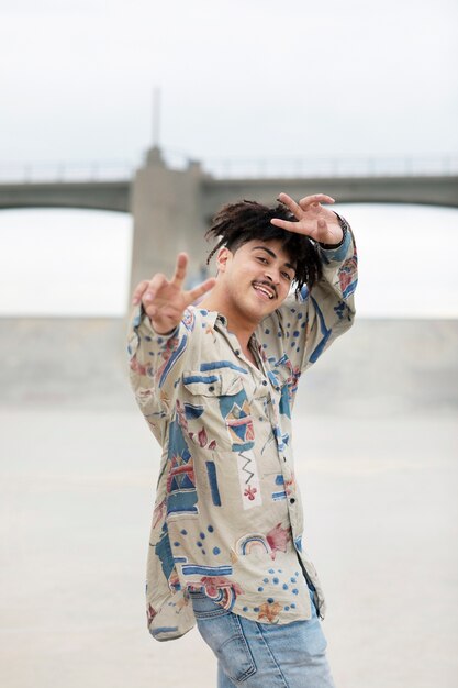 Young man posing and showing the peace sign while out in the city