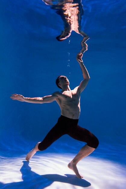 Young man posing submerged underwater