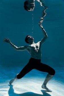 Young man posing submerged underwater