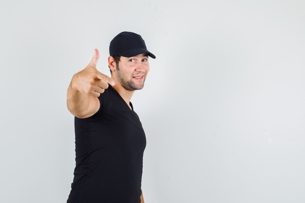 Young man posing while showing gun gesture in black t-shirt