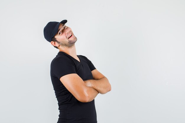 Young man posing with crossed arms in black t-shirt