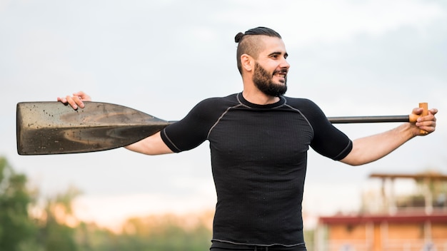 Free photo young man posing with oar