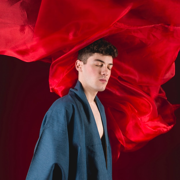 Young man posing with red cloth