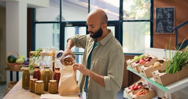 Young man pouring pasta into bag