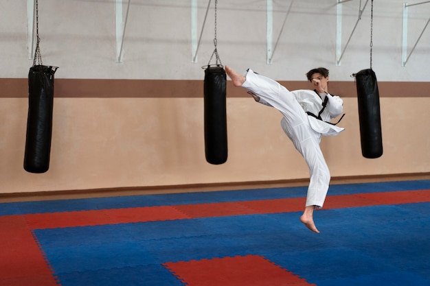 Free photo young man practicing taekwondo in a gymnasium