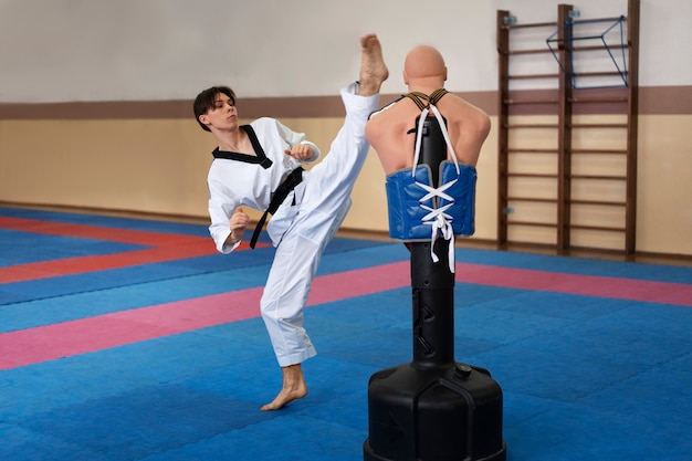 Free photo young man practicing taekwondo in a gymnasium