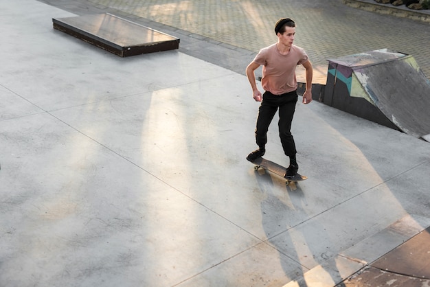 Free photo young man practising with the skateboard