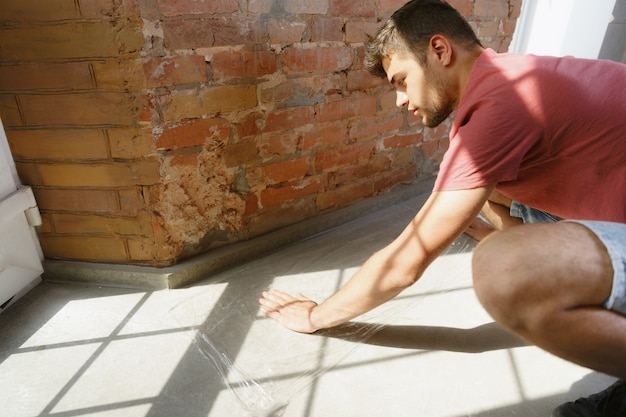 Free photo young man preparing for doing apartment repair by hisselfes. before home makeover or renovation