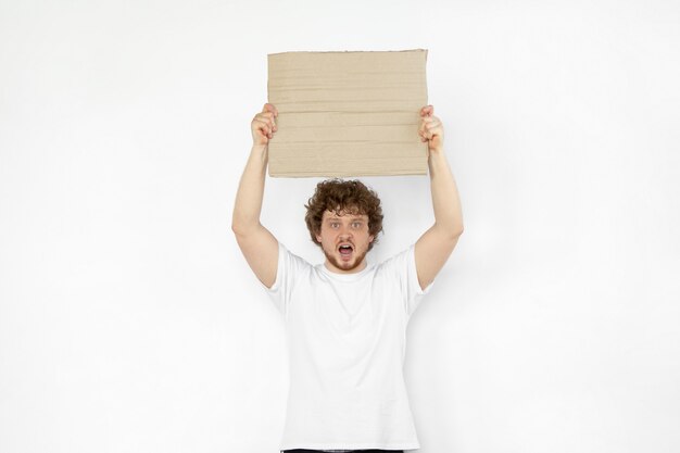 Young man protesting with blank board