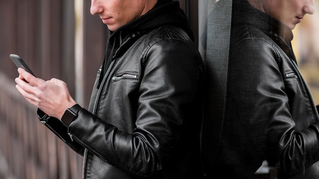 Free photo young man putting music on earphones outside