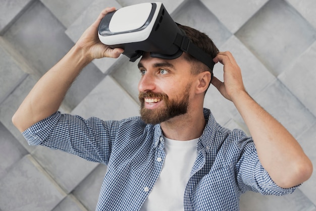 Free photo young man putting on virtual headset