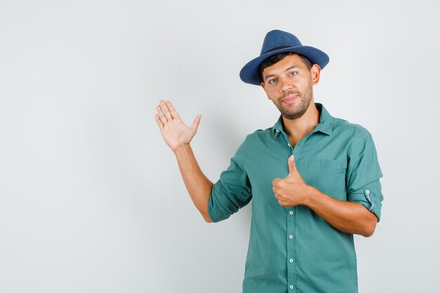 Young man raising open palm with thumb up in shirt