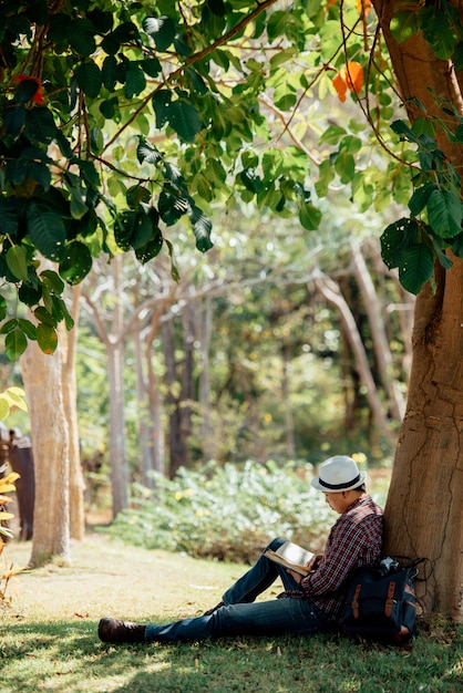 若い男が夏の芝生で本を読んで