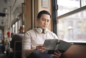 若い男は路面電車で新聞を読む