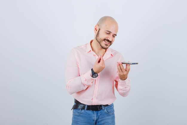 Young man recording a voice message on mobile phone