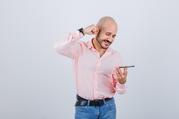 Young man recording a voice message on mobile phone