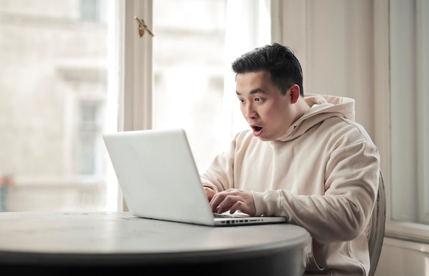 young man rejoices happy in front of a computer