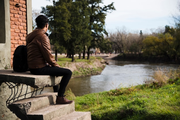 Young man relaxing by the water