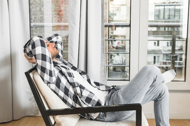 Free photo young man relaxing on chair at home