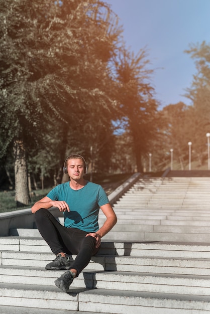 Young man resting after doing sport in the park