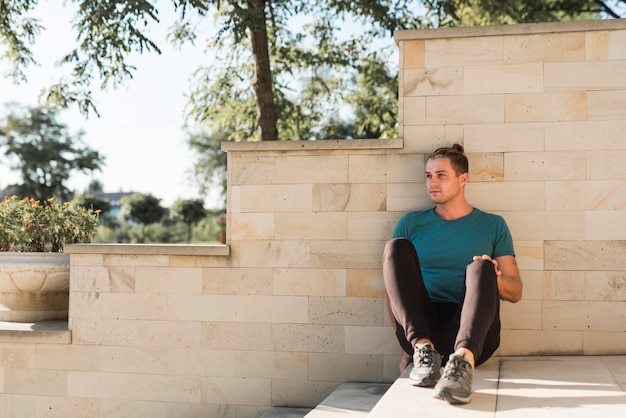 Young man resting after doing sport in the park