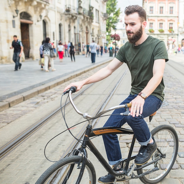 Foto gratuita bicicletta di guida del giovane in città
