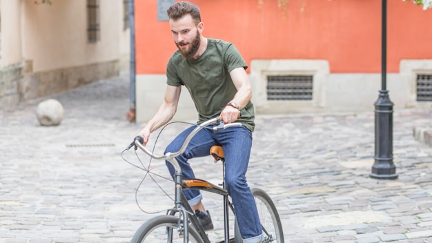 Young man riding bicycle on pavement