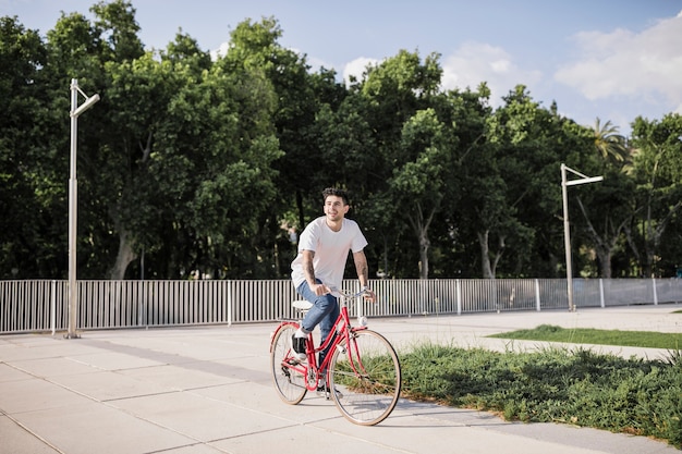 Young man riding bike in park