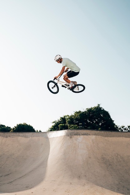 Young man riding bmx bicycle on a ramp