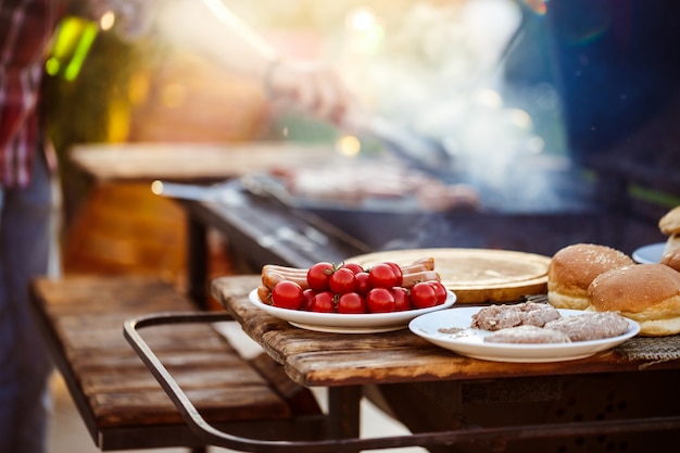 若い男がグリルでバーベキューを焙煎します。食べ物に焦点を当てます。