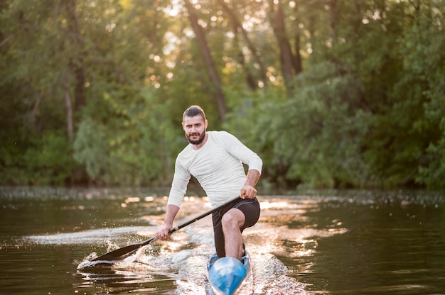 Young man rowing outdoors