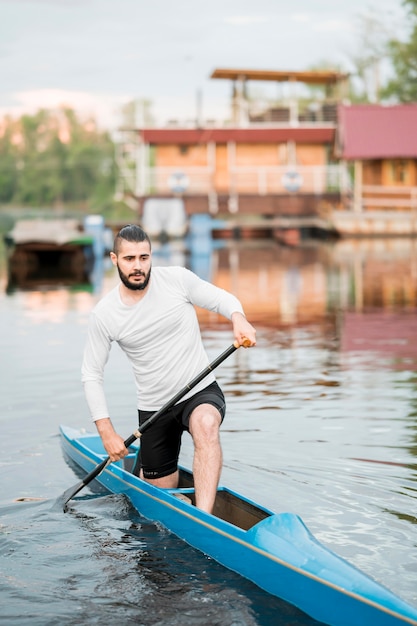 Young man rowing with paddle