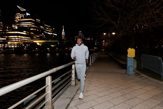 Young man running at night by a river