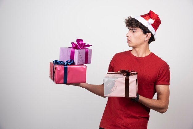 선물을 보고 산타 모자에 젊은 남자.